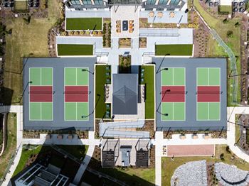an aerial view of several tennis courts on a city
